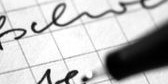 Stift in Nahansicht der auf einen Zettel schreibt